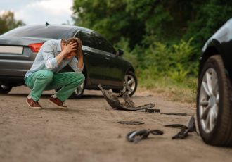 Upset male drivers after car accident on road. Automobile crash. Broken automobile or damaged vehicle, auto collision on highway