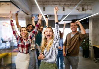 Group of successful business people in office celebrating profits and team building